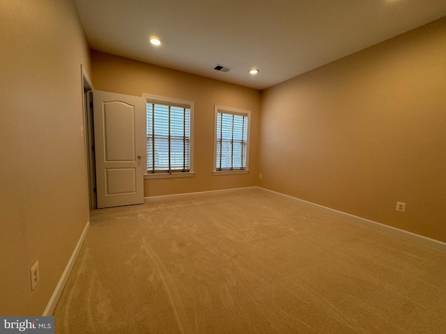 empty room with recessed lighting, visible vents, baseboards, and light carpet