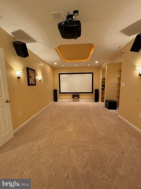 cinema room with recessed lighting, baseboards, a raised ceiling, and carpet