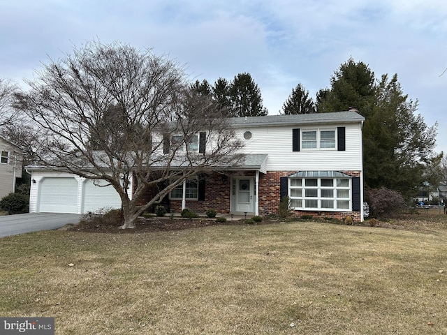 traditional-style house featuring an attached garage, brick siding, driveway, and a front lawn