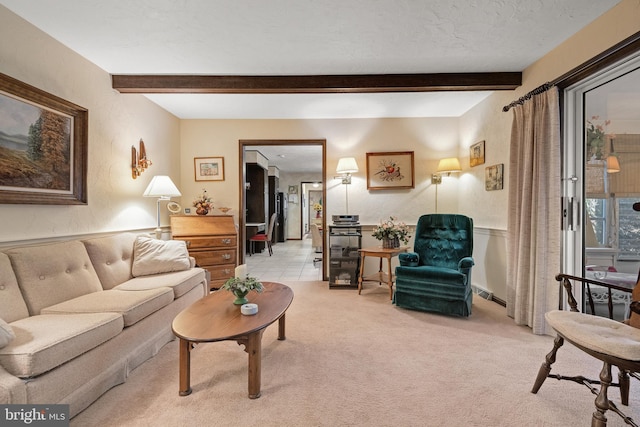 living room with light colored carpet, beamed ceiling, and a textured ceiling