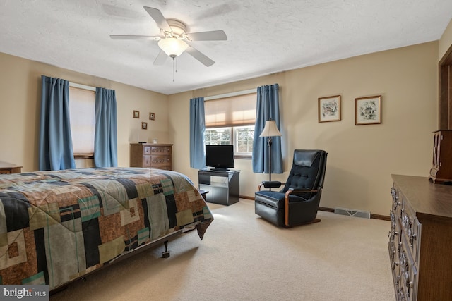 bedroom with baseboards, a textured ceiling, visible vents, and carpet flooring