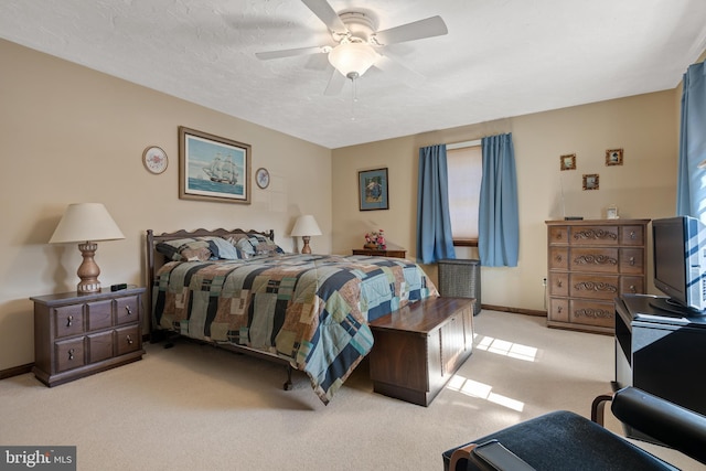 bedroom featuring a ceiling fan, baseboards, a textured ceiling, and light colored carpet