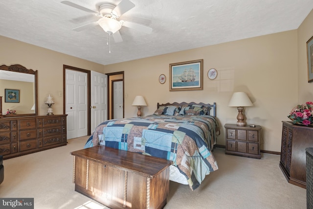 carpeted bedroom with ceiling fan, baseboards, and a textured ceiling