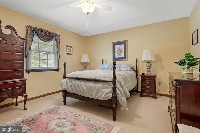 bedroom with light colored carpet, ceiling fan, and baseboards