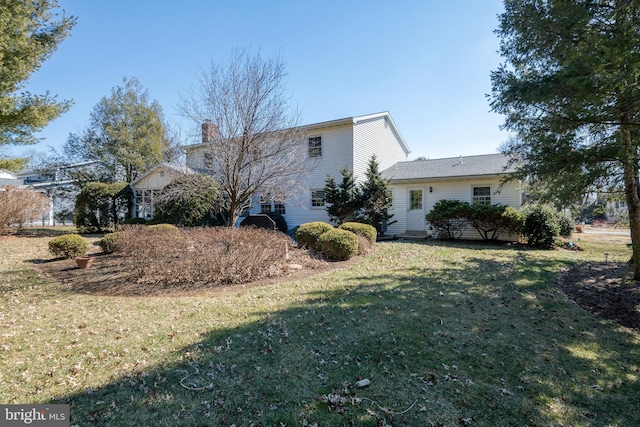 exterior space featuring a lawn and a chimney