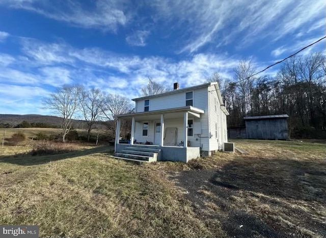 view of front of property featuring a chimney, a porch, and central AC