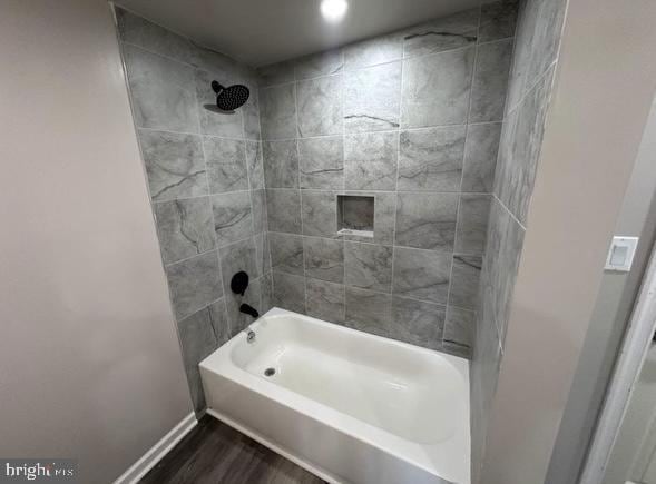 bathroom with  shower combination, wood finished floors, and baseboards