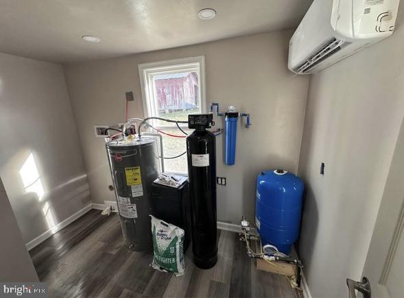 utilities with water heater and a wall mounted AC