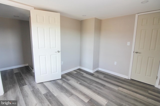 empty room with baseboards and wood finished floors