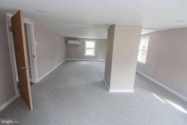 below grade area with carpet, baseboards, a wealth of natural light, and a wall mounted AC