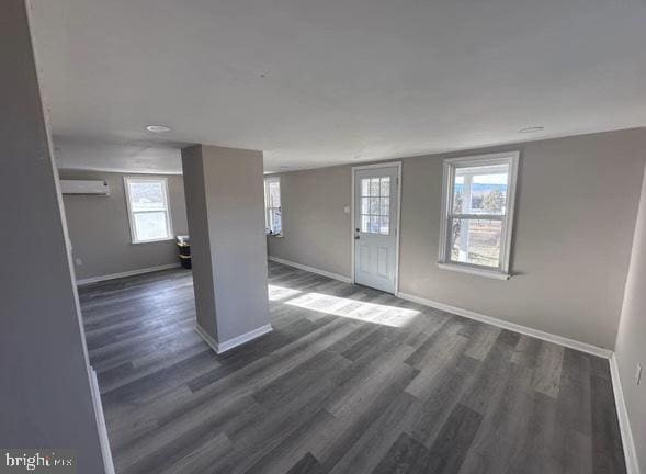 entryway with dark wood finished floors, a wealth of natural light, and baseboards