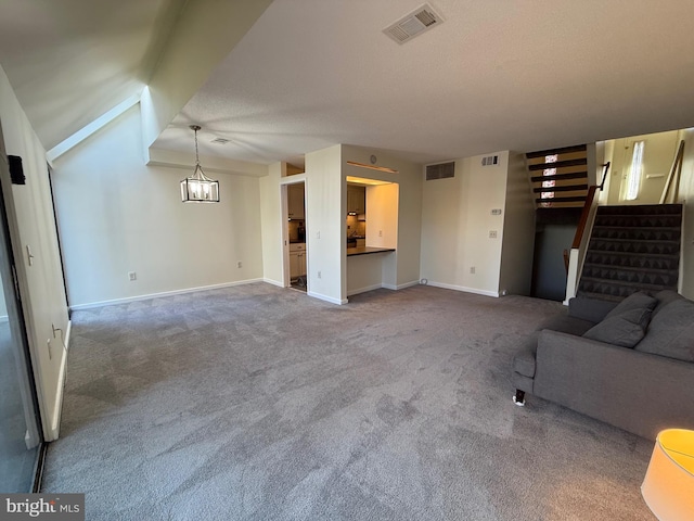 unfurnished living room with stairway, carpet flooring, visible vents, and baseboards