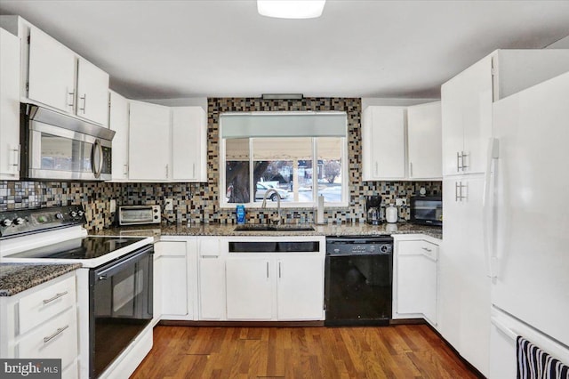 kitchen featuring a sink, white cabinets, dark stone counters, black appliances, and tasteful backsplash