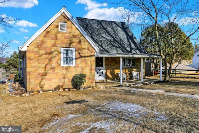 view of front of home featuring covered porch, roof with shingles, and fence