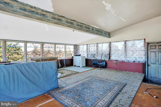 sunroom featuring lofted ceiling with beams