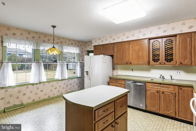 kitchen featuring a sink, wallpapered walls, white fridge with ice dispenser, and stainless steel dishwasher