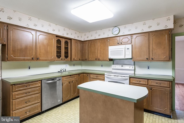 kitchen with white appliances, a sink, light floors, and wallpapered walls