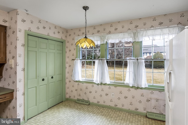 unfurnished dining area with visible vents, plenty of natural light, and wallpapered walls