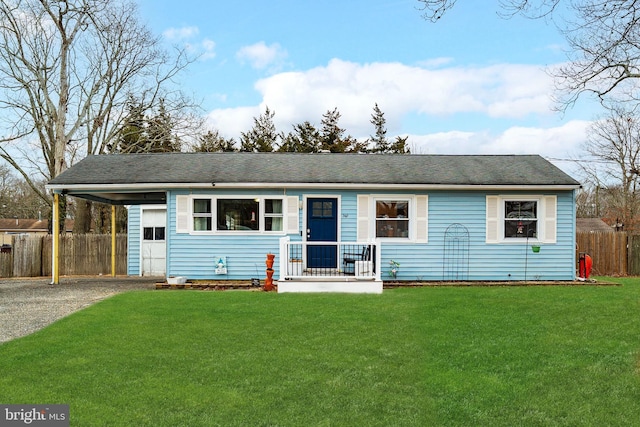 ranch-style house with a carport, a front yard, fence, and driveway