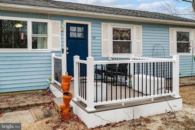 entrance to property with roof with shingles