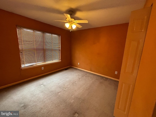 empty room featuring carpet flooring, ceiling fan, and baseboards