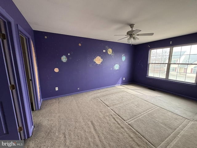 empty room featuring a ceiling fan, visible vents, baseboards, and carpet flooring