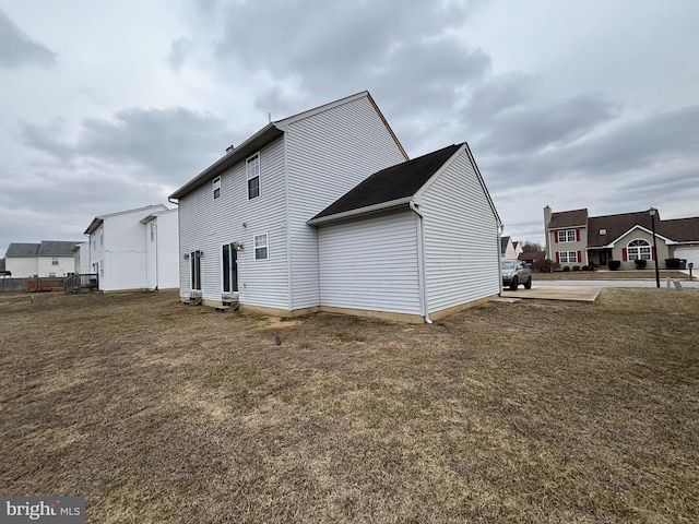 back of house featuring a lawn