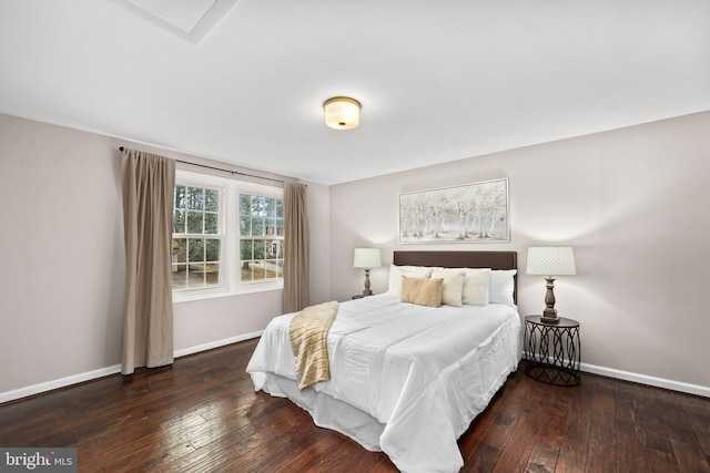 bedroom with baseboards and dark wood finished floors