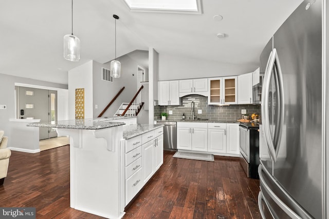 kitchen with glass insert cabinets, white cabinetry, appliances with stainless steel finishes, and a sink