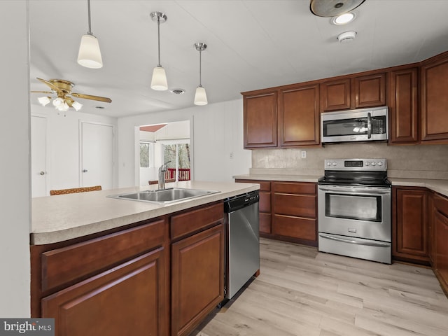 kitchen featuring stainless steel appliances, light countertops, and a sink