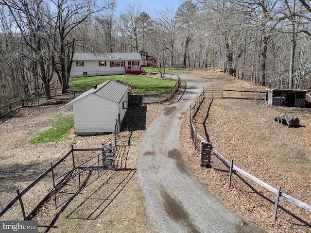 view of yard with central air condition unit, an outbuilding, driveway, and fence