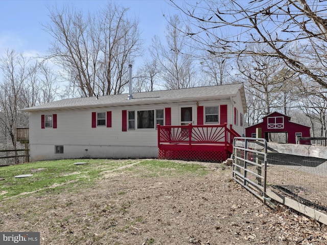 view of front of home with roof with shingles, an outdoor structure, and fence