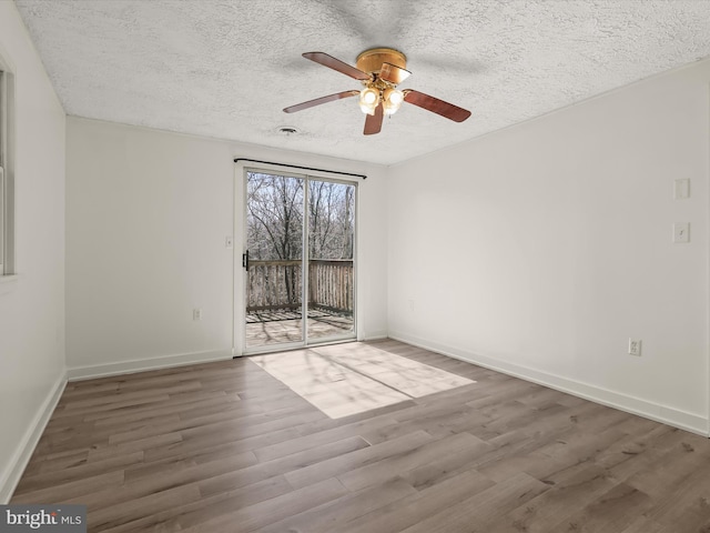 unfurnished room featuring wood finished floors, baseboards, and a textured ceiling