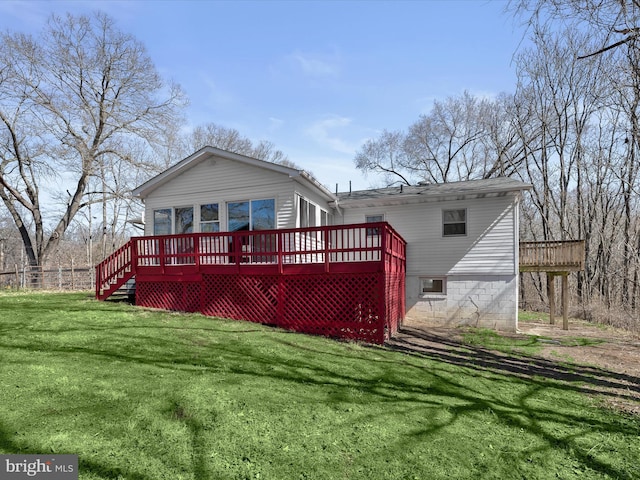 rear view of property with a yard and a wooden deck