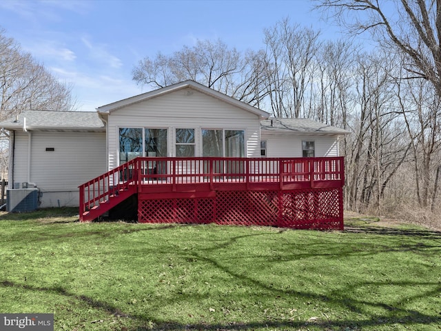 rear view of property featuring central AC unit, a lawn, and a wooden deck