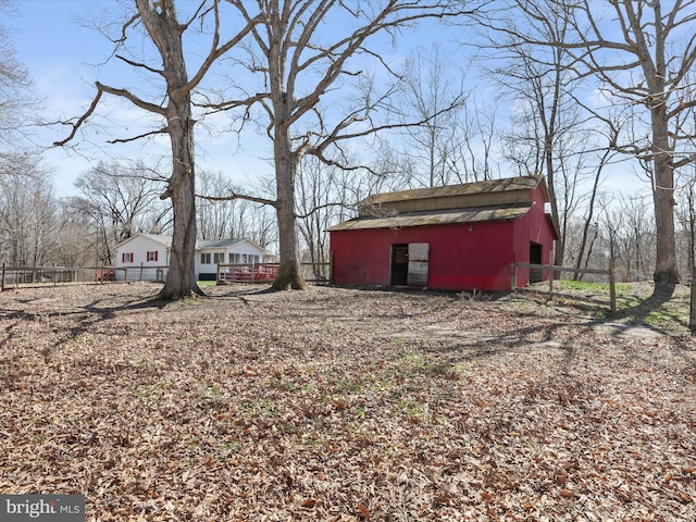 view of yard featuring an outbuilding, a barn, and fence