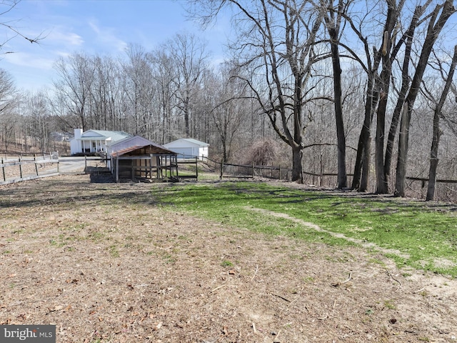 view of yard with an outbuilding, fence, and exterior structure