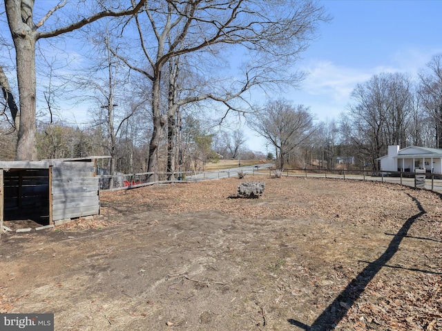 view of yard featuring an outbuilding and fence