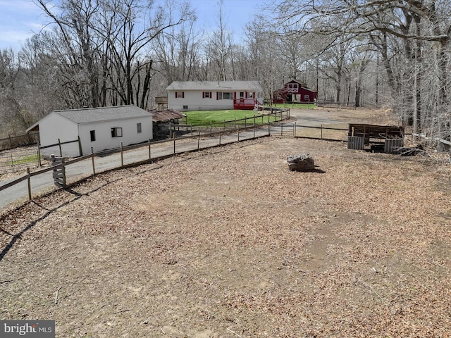 view of yard featuring an outdoor structure and fence