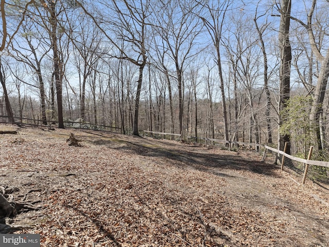 view of yard with fence and a forest view