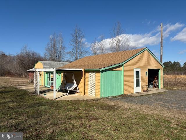 back of property with a lawn and a detached garage