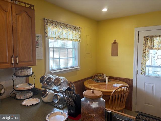 dining area with a wainscoted wall and electric panel