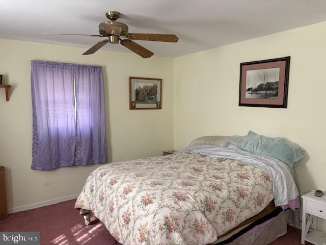 bedroom featuring dark carpet, a ceiling fan, and baseboards