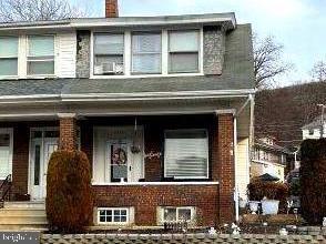 view of front facade with a chimney and brick siding