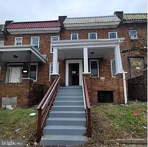 multi unit property with a tiled roof, brick siding, and mansard roof