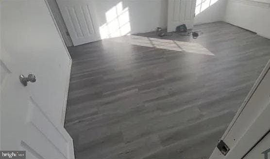 living area with radiator heating unit and wood finished floors