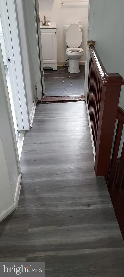 bathroom featuring toilet, a sink, and wood finished floors