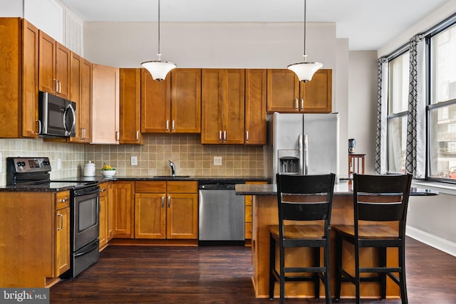 kitchen featuring a sink, appliances with stainless steel finishes, decorative backsplash, baseboards, and dark wood-style flooring