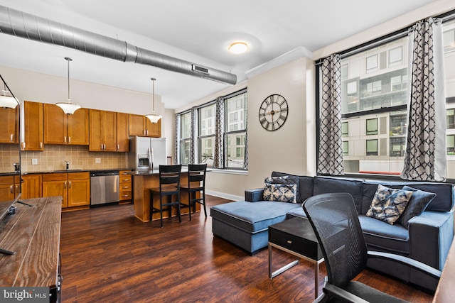 living area featuring dark wood-type flooring and baseboards