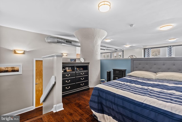 bedroom featuring baseboards and wood finished floors